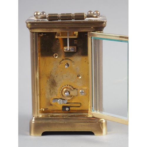 98 - A brass cased carriage clock with white enamel dial and Roman numerals, with key