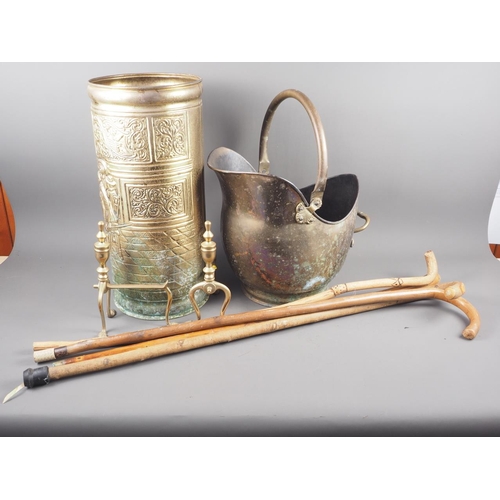 129 - A copper coal helmet, a pair of brass implement rests, a brass stick stand and four walking sticks