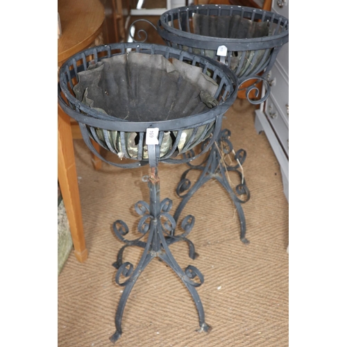 694 - A pair of wrought iron scrollwork adjustable height planters, on splay supports, 21