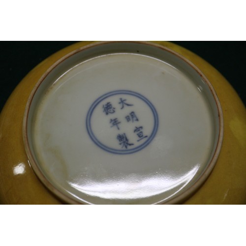 72 - A Chinese yellow glazed shallow dish with six-character mark to base, 7