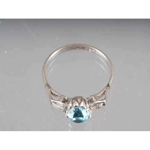 285 - A 9ct gold and platinum dress ring, set blue zircon with two emerald cut zircons to shoulders, size ... 