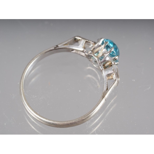 285 - A 9ct gold and platinum dress ring, set blue zircon with two emerald cut zircons to shoulders, size ... 