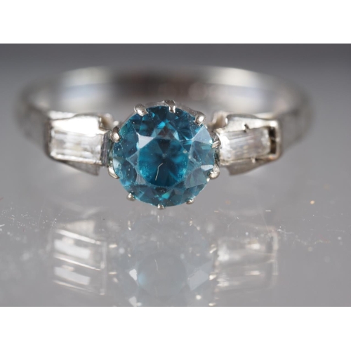 285 - A 9ct gold and platinum dress ring, set blue zircon with two emerald cut zircons to shoulders, size ... 