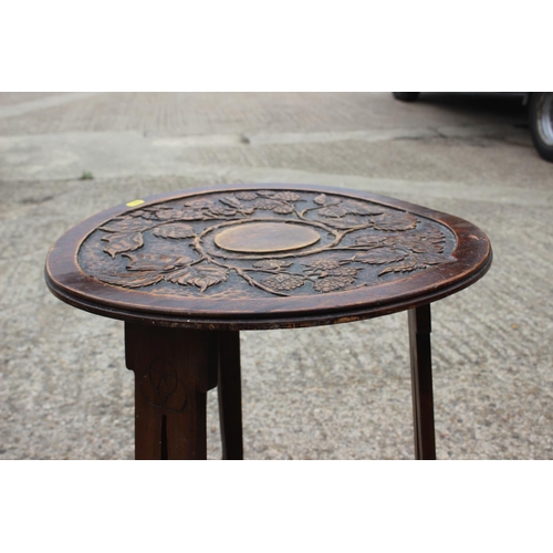 511 - An early 20th century carved walnut circular top two-tier occasional table, on panel supports, 18 1/... 