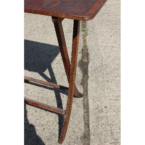 537 - An early 20th century pokerwork folding table, on 'X' frame supports, 30