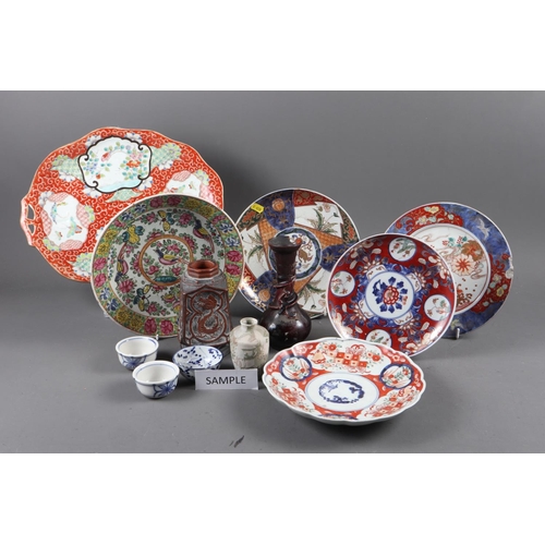 125 - Three Chinese Imari plates (damages), a Chinese serving dish with panelled decoration on a red groun... 