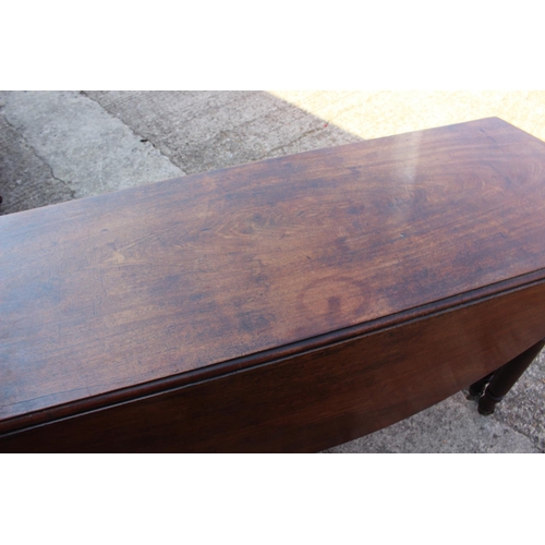 403 - A mid 19th century mahogany oval drop leaf dining table, on six turned castored supports, 48