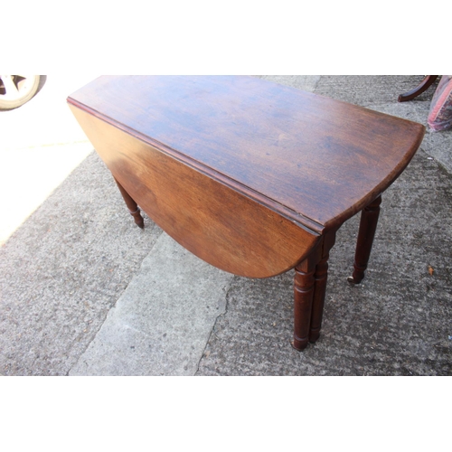 403 - A mid 19th century mahogany oval drop leaf dining table, on six turned castored supports, 48