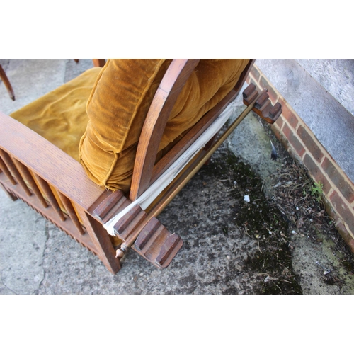 453 - A Liberty style oak framed reclining armchair with loose cushions upholstered in an old gold velvet