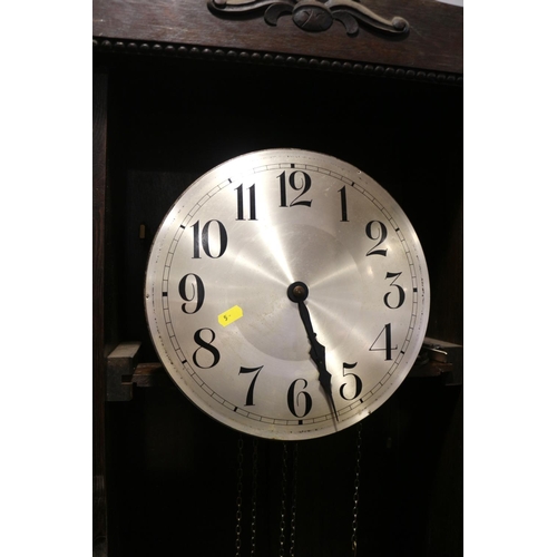 463 - A 1930s oak long case clock with silvered dial and eight-day striking and chiming movement enclosed ... 