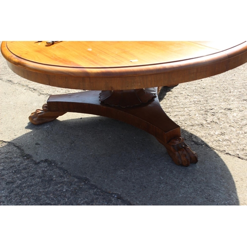 501 - A mahogany circular top low coffee table, on triform base and lion paw supports, 42