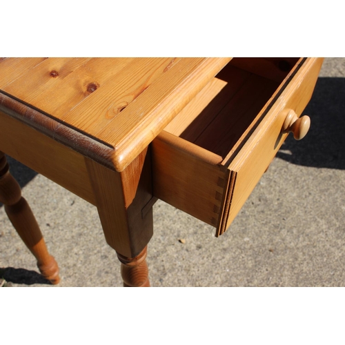 566 - A waxed pine dressing table, fitted two drawers, on turned supports, 32