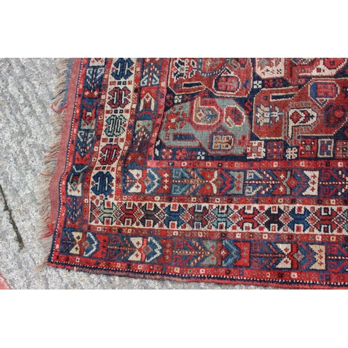 574 - A Caucasian tribal wool rug with stylised cypress tree and geometric designs with multi-guard border... 