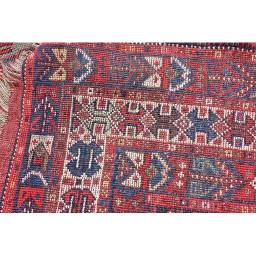 574 - A Caucasian tribal wool rug with stylised cypress tree and geometric designs with multi-guard border... 