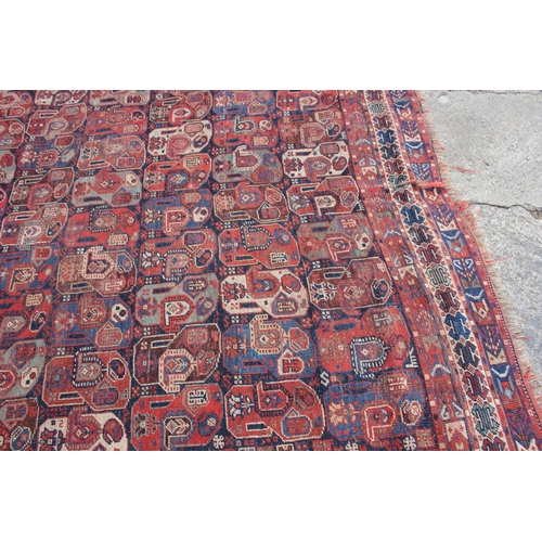 574 - A Caucasian tribal wool rug with stylised cypress tree and geometric designs with multi-guard border... 