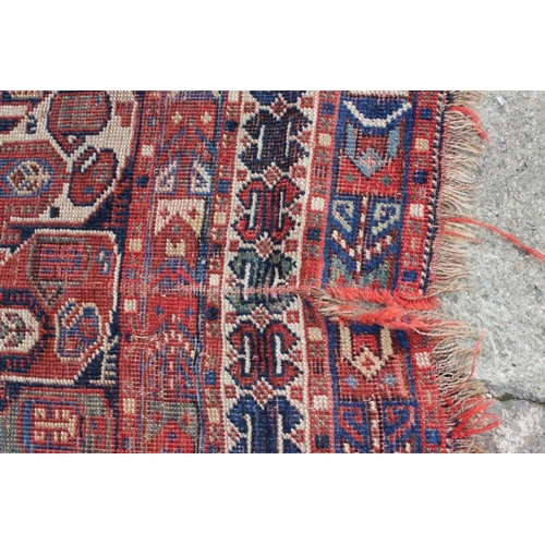 574 - A Caucasian tribal wool rug with stylised cypress tree and geometric designs with multi-guard border... 