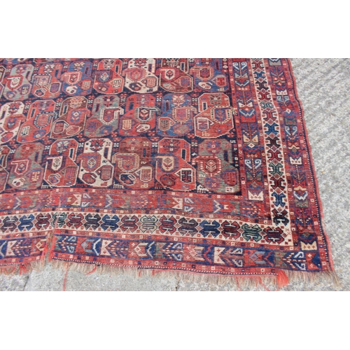 574 - A Caucasian tribal wool rug with stylised cypress tree and geometric designs with multi-guard border... 