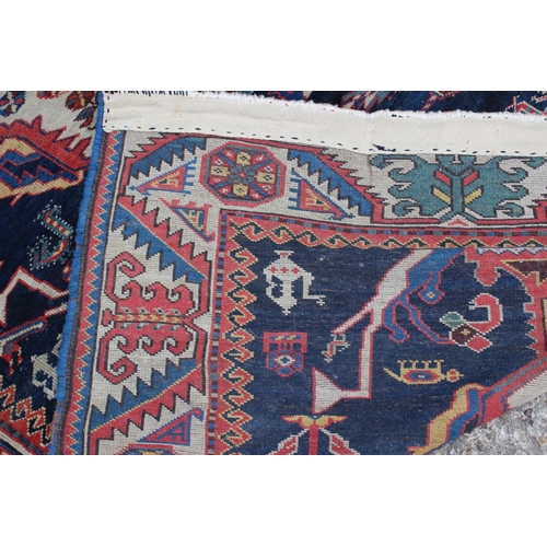 575 - A Hamadan wool rug with three central medallions with geometric and animal designs on a dark blue gr... 