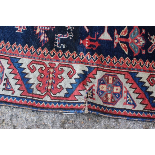 575 - A Hamadan wool rug with three central medallions with geometric and animal designs on a dark blue gr... 