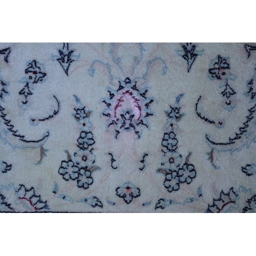 587 - An Isfahan wool and silk detailed rug with all-over pageant and scroll design in shades of blue, red... 