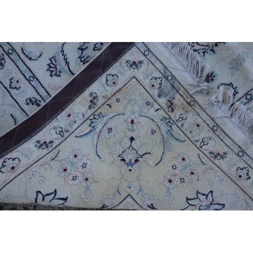 587 - An Isfahan wool and silk detailed rug with all-over pageant and scroll design in shades of blue, red... 