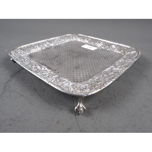 270 - A white metal square card tray with embossed floral decoration, on paw feet, 8 3/4