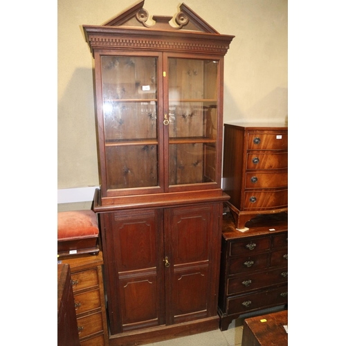 394 - A 19th century mahogany bookcase with broken pediment over two glazed doors and two panelled doors, ... 