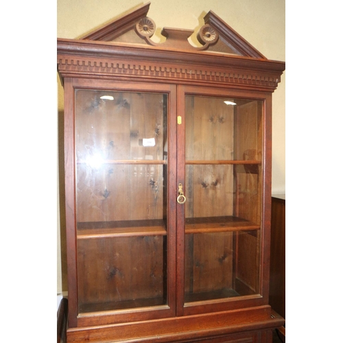 394 - A 19th century mahogany bookcase with broken pediment over two glazed doors and two panelled doors, ... 