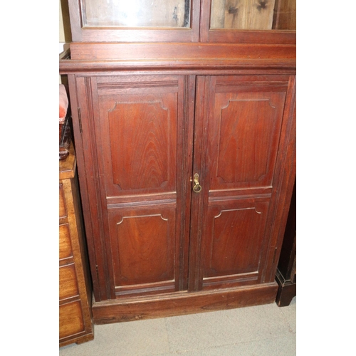 394 - A 19th century mahogany bookcase with broken pediment over two glazed doors and two panelled doors, ... 