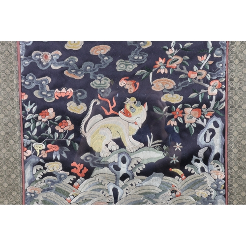 196 - A Chinese silk embroidered Mandarin rank badge with mythical beast in a landscape design, in gilt fr... 