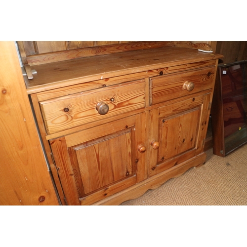 542 - A waxed pine dresser, the upper section fitted four drawers over two drawers and cupboards, on block... 