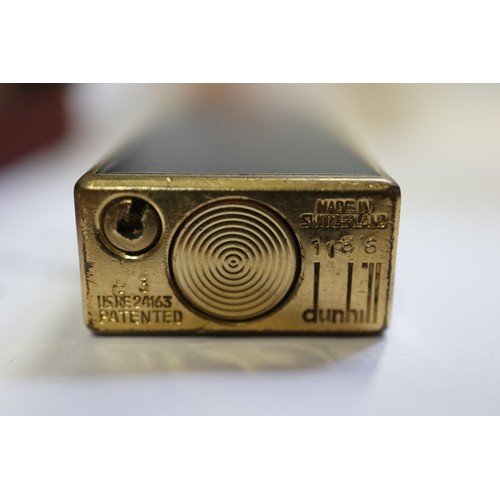 209 - A Dunhill black and gilt metal slimline cigarette lighter, Serial No 1156, in original box