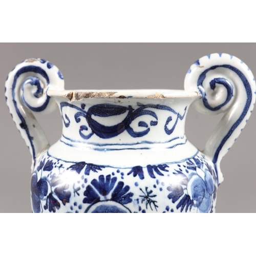 23 - An 18th century Delftware two-handled vase with blue and white floral decoration, on circular base, ... 