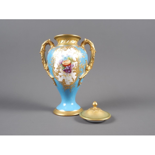 34 - An early 20th century Royal Worcester two-handle vase and cover with fruit decorated panel on a blue... 