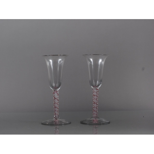 85 - A pair of 19th century bell bowl wines with red and white cotton twist stems, 6.2