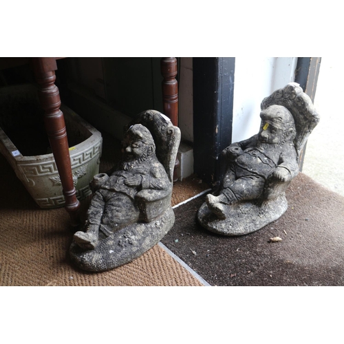 781 - Two cast stone resting gnomes in armchairs and two smaller gnomes