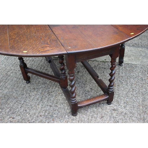 462 - An early Georgian oval drop leaf dining table, on tapering barley twist gate leaf supports, 50