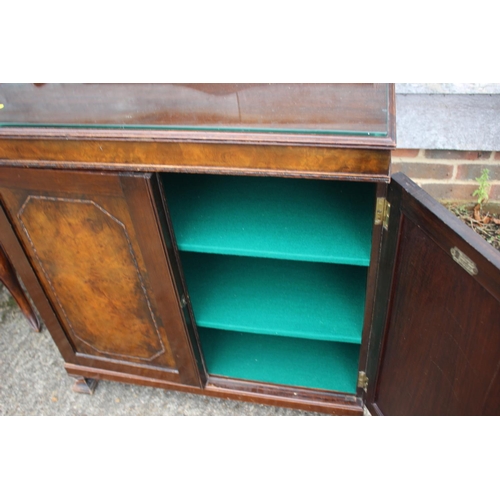 545 - A figured walnut ledge back side cupboard with felt lined shelves enclosed two doors, on shaped feet... 