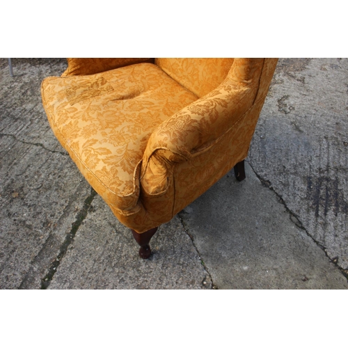 552 - A wing armchair of early Georgian design with loose seat cushion, upholstered in an old gold brocade... 