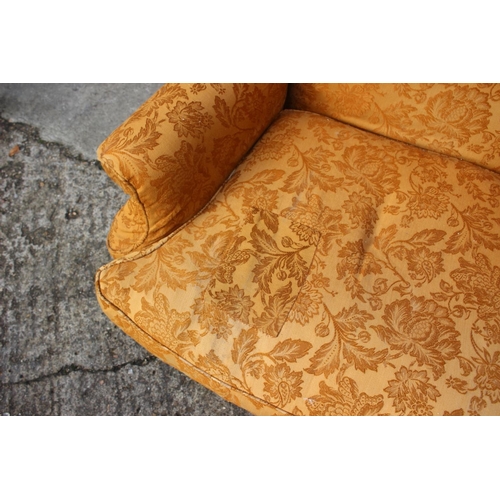 552 - A wing armchair of early Georgian design with loose seat cushion, upholstered in an old gold brocade... 