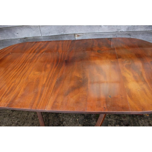 553 - A mahogany double pedestal dining table with extra leaf, on vase finial columns and tripod splay sup... 