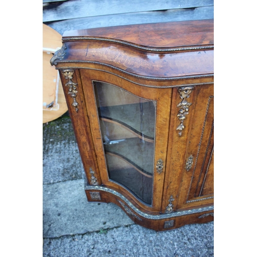 446 - A mid Victorian figured walnut and gilt bronze mounted serpentine front credenza with central door a... 