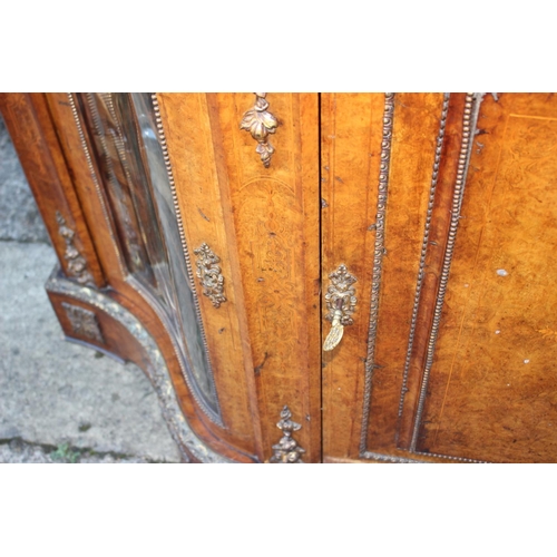 446 - A mid Victorian figured walnut and gilt bronze mounted serpentine front credenza with central door a... 