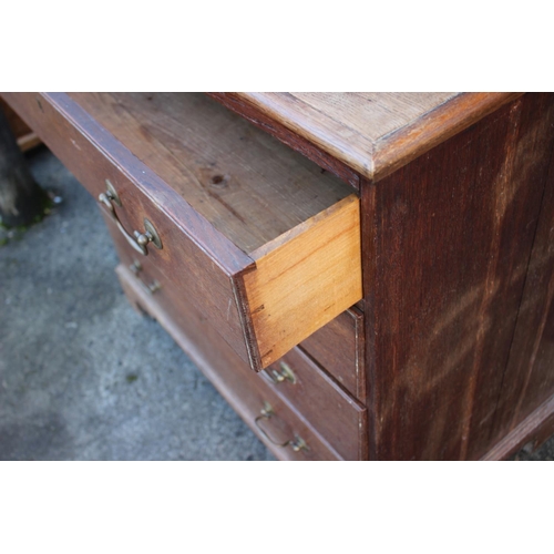 450 - An early 19th century provincial oak chest of four graduated long drawers, with brass bail handles, ... 