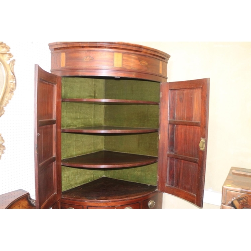 469 - A late Georgian mahogany and inlaid bowfront corner cupboard, the upper section fitted shelves and e... 