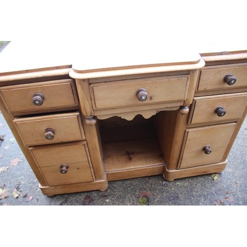 595 - A 19th century waxed pine breakfront desk with central recess, fitted seven drawers, 44