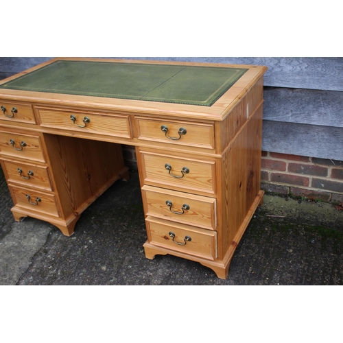 596 - A waxed pine double pedestal desk with green leather top, fitted nine drawers, on bracket feet, 50