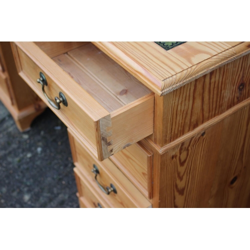 596 - A waxed pine double pedestal desk with green leather top, fitted nine drawers, on bracket feet, 50