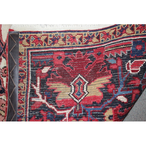 601 - A Persian carpet with floral designs and multi-borders on a red ground in shades of dark blue and na... 