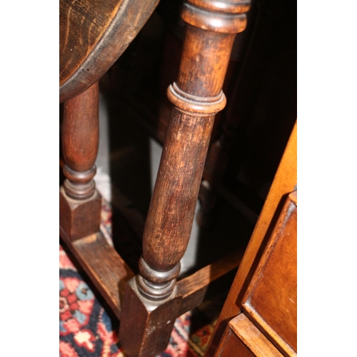 484 - An oak oval top gate leg dining table, on turned and stretchered supports, 34